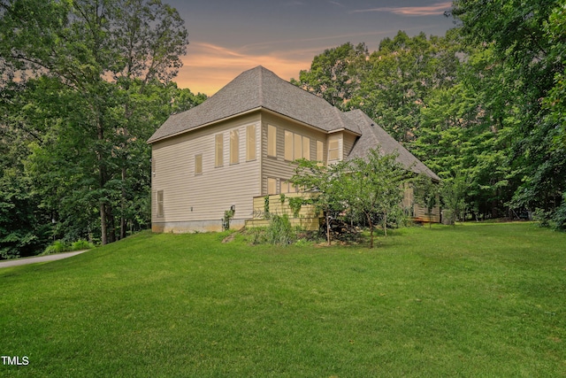 property exterior at dusk with a yard