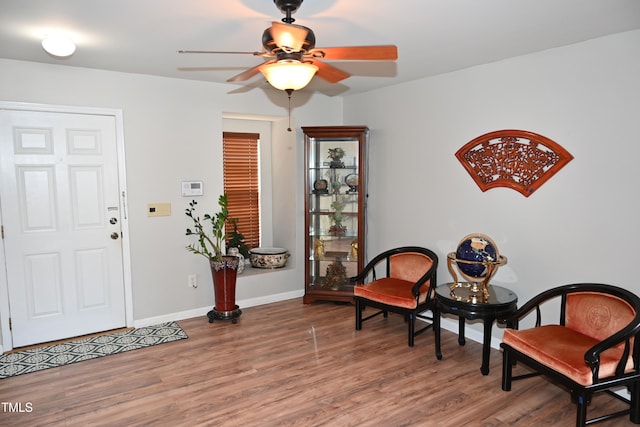 sitting room featuring wood-type flooring and ceiling fan