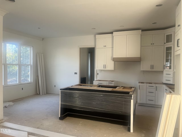 kitchen with white cabinets and wall chimney exhaust hood