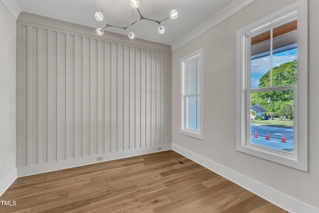 unfurnished dining area featuring baseboards, light wood-type flooring, an inviting chandelier, and crown molding