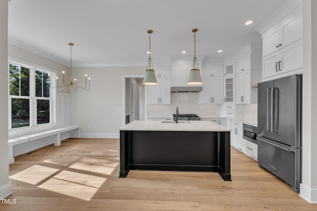 kitchen with baseboards, an inviting chandelier, light countertops, high quality fridge, and white cabinetry