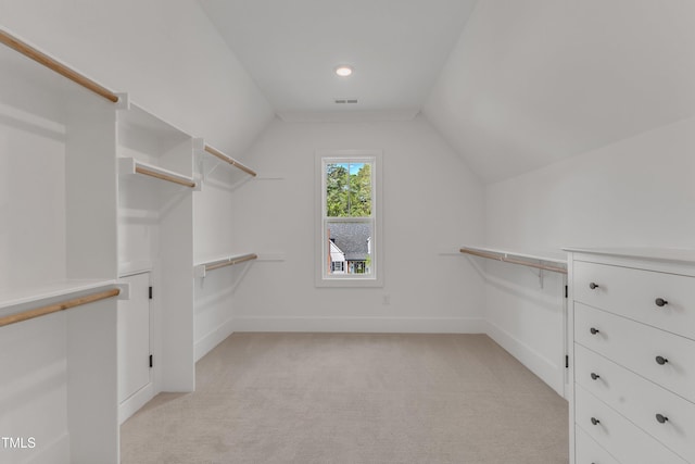 walk in closet featuring light carpet, visible vents, and vaulted ceiling