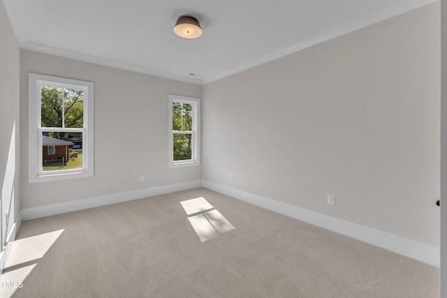 unfurnished room featuring plenty of natural light, baseboards, light colored carpet, and crown molding
