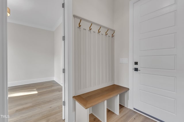 mudroom featuring crown molding, light wood-style flooring, and baseboards