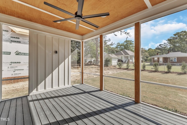 unfurnished sunroom with a ceiling fan