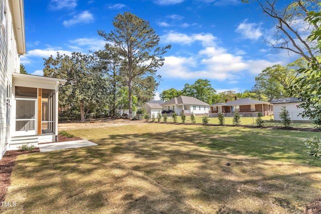 view of yard featuring fence and a sunroom