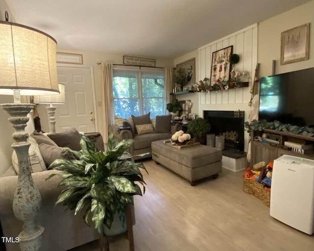 living area with a large fireplace and wood finished floors
