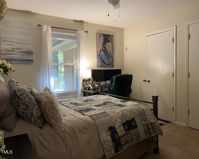 bedroom featuring a ceiling fan, carpet, a closet, and a textured ceiling