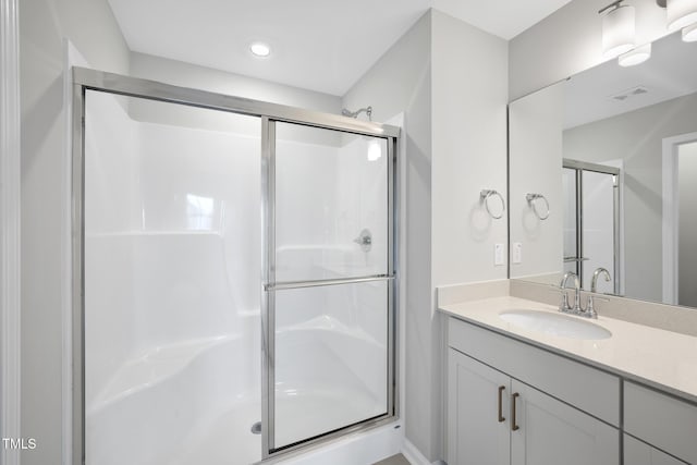 bathroom with vanity and a shower with door