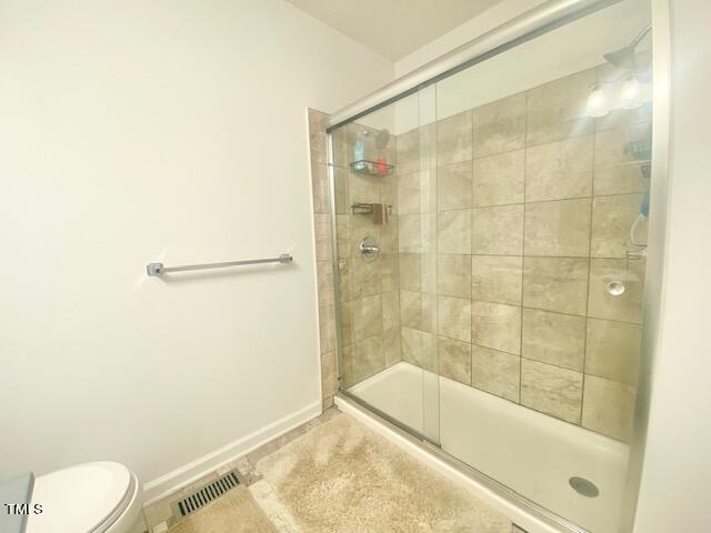 bathroom with walk in shower and toilet