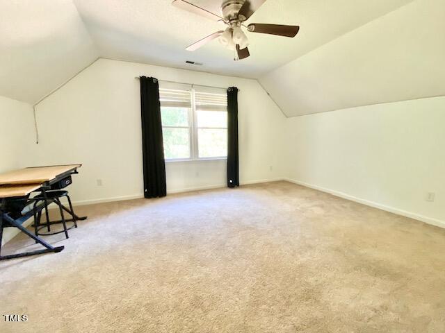 bonus room featuring light carpet, lofted ceiling, and ceiling fan