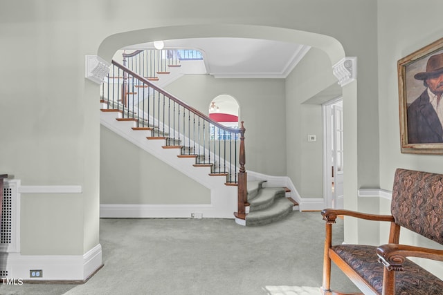 carpeted entrance foyer with crown molding