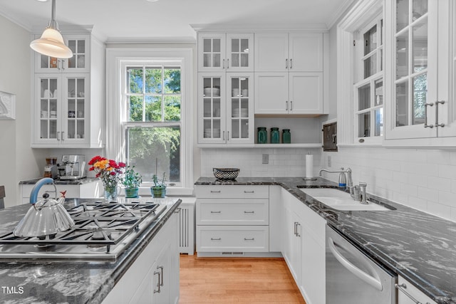 kitchen with appliances with stainless steel finishes, white cabinets, and hanging light fixtures