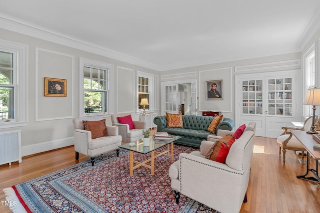 living room featuring light hardwood / wood-style flooring, radiator heating unit, and crown molding