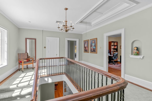 corridor featuring a notable chandelier, ornamental molding, and light hardwood / wood-style flooring