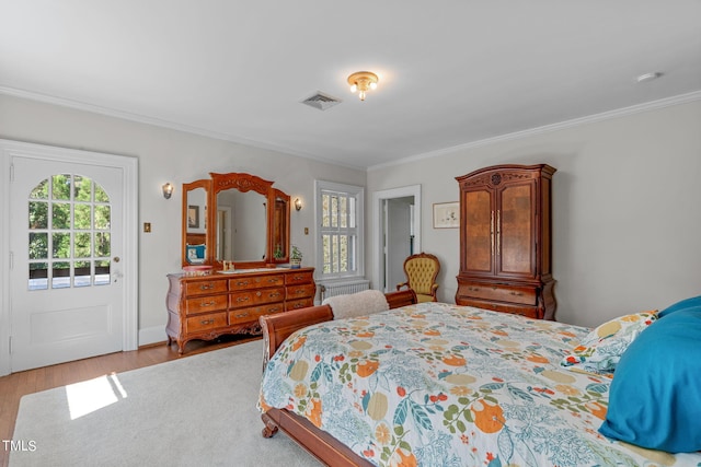 bedroom featuring ornamental molding, access to exterior, and wood-type flooring