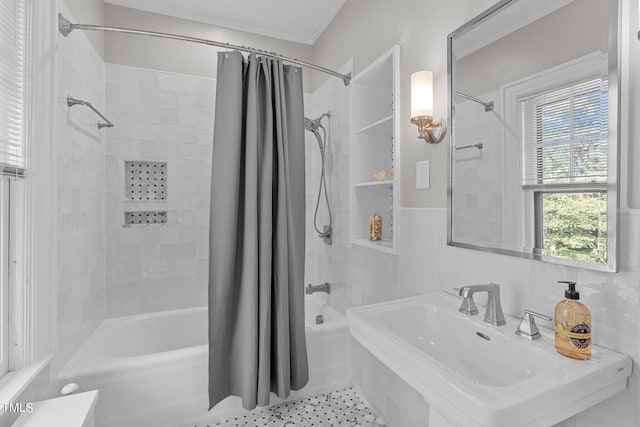 bathroom with shower / tub combo with curtain, tile patterned floors, tile walls, and sink