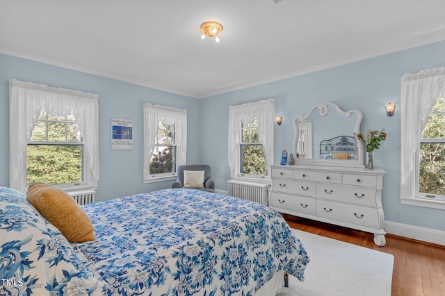 bedroom featuring ornamental molding, hardwood / wood-style floors, and radiator