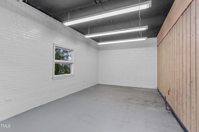 unfurnished room with wood walls and brick wall