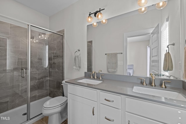 bathroom featuring tile patterned flooring, a shower with shower door, vanity, and toilet