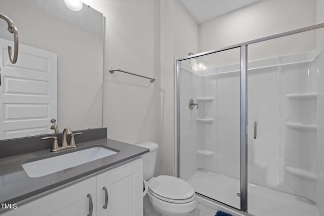 bathroom with vanity, toilet, and an enclosed shower