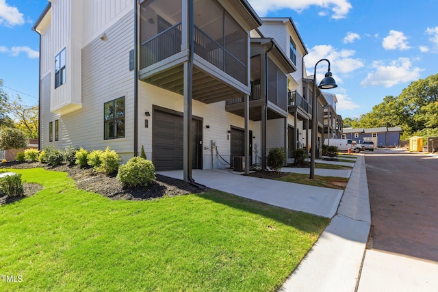 view of side of property featuring a garage and a lawn