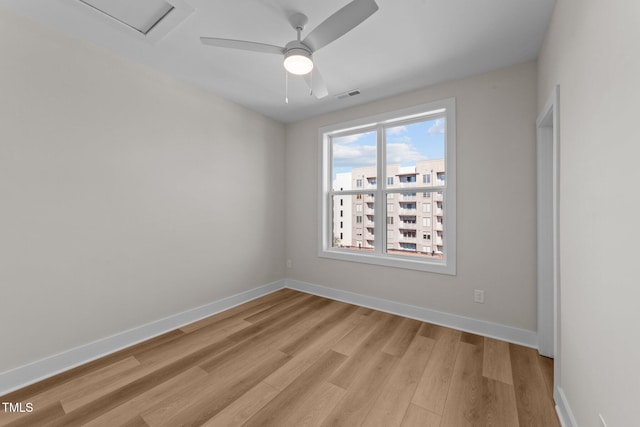 empty room with ceiling fan and light hardwood / wood-style floors