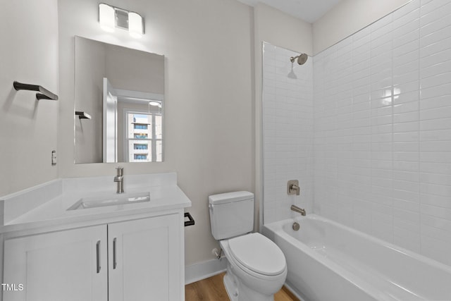 full bathroom with tiled shower / bath combo, vanity, toilet, and hardwood / wood-style floors