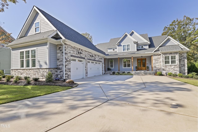 craftsman house with a garage, driveway, roof with shingles, and stone siding