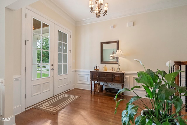 doorway to outside with an inviting chandelier, ornamental molding, and wood-type flooring