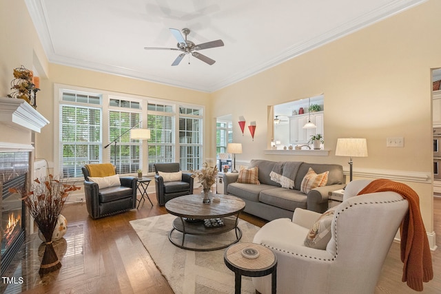 living room with ornamental molding, hardwood / wood-style flooring, and ceiling fan