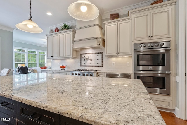 kitchen with dark hardwood / wood-style flooring, light stone counters, stainless steel appliances, pendant lighting, and crown molding