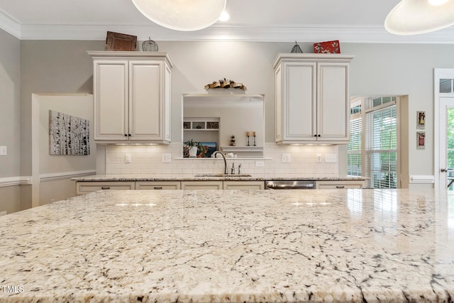 kitchen with backsplash, ornamental molding, sink, and dishwasher