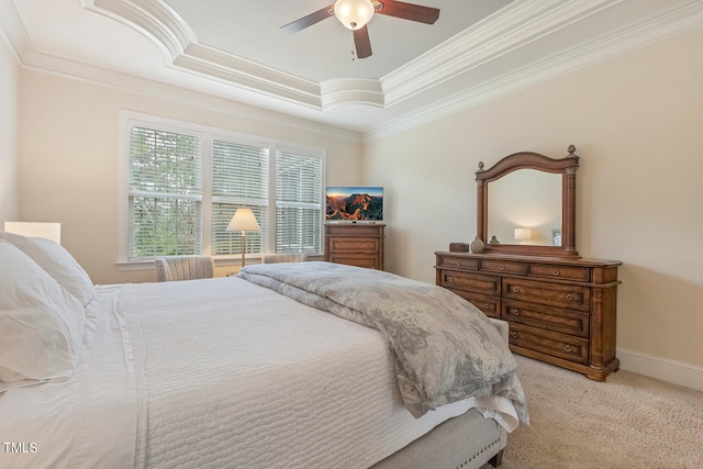 carpeted bedroom with ceiling fan, a raised ceiling, and ornamental molding