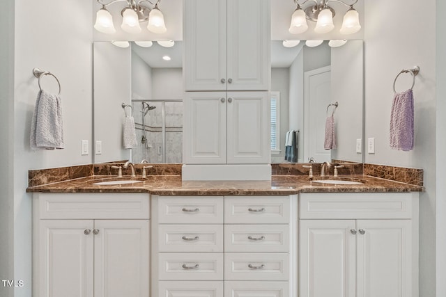 bathroom featuring a shower with door and vanity