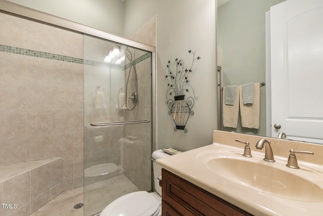 bathroom with toilet, a shower with shower door, and vanity