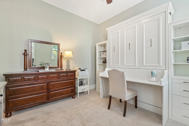 home office with ceiling fan, light colored carpet, and built in desk