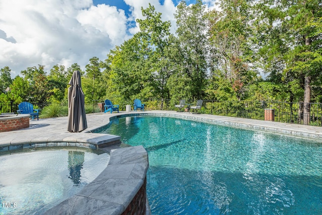 view of pool featuring a patio and an in ground hot tub