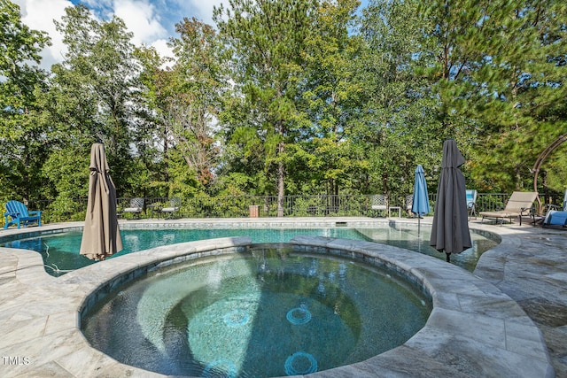 view of swimming pool with an in ground hot tub and a patio area