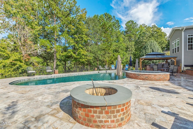 view of pool with a patio, a gazebo, and an in ground hot tub