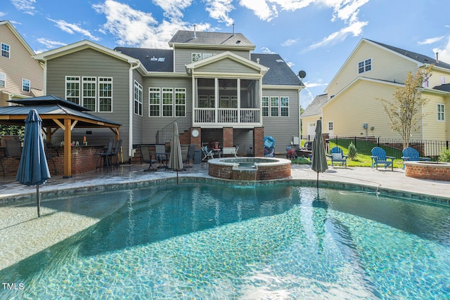 view of pool featuring an in ground hot tub, a gazebo, a sunroom, and a patio