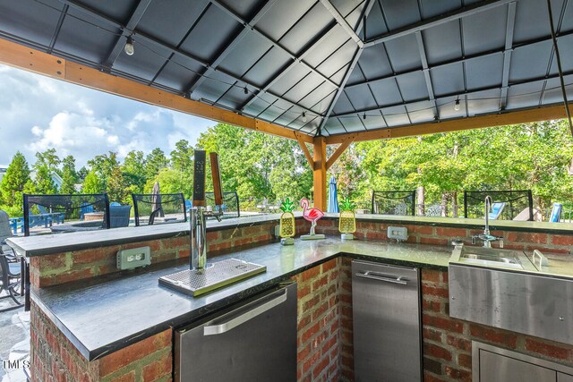 view of patio with a gazebo, an outdoor kitchen, and a wet bar