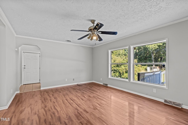 spare room featuring ceiling fan, a textured ceiling, light hardwood / wood-style flooring, and crown molding