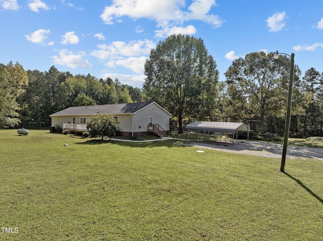 view of yard with a carport and a wooden deck