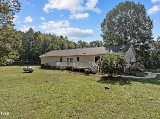 rear view of house featuring a deck and a yard