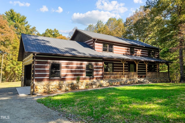 cabin with covered porch and a front lawn