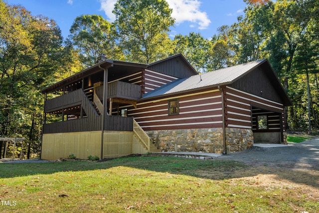 view of side of property featuring a wooden deck and a lawn