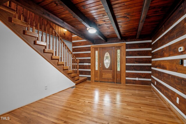 entrance foyer with wood ceiling, beamed ceiling, light wood-type flooring, and wooden walls