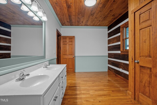 bathroom with wood ceiling, wood-type flooring, ornamental molding, vanity, and wooden walls