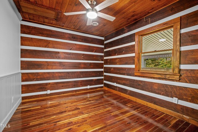 unfurnished room with ceiling fan, wood ceiling, wood walls, and hardwood / wood-style floors